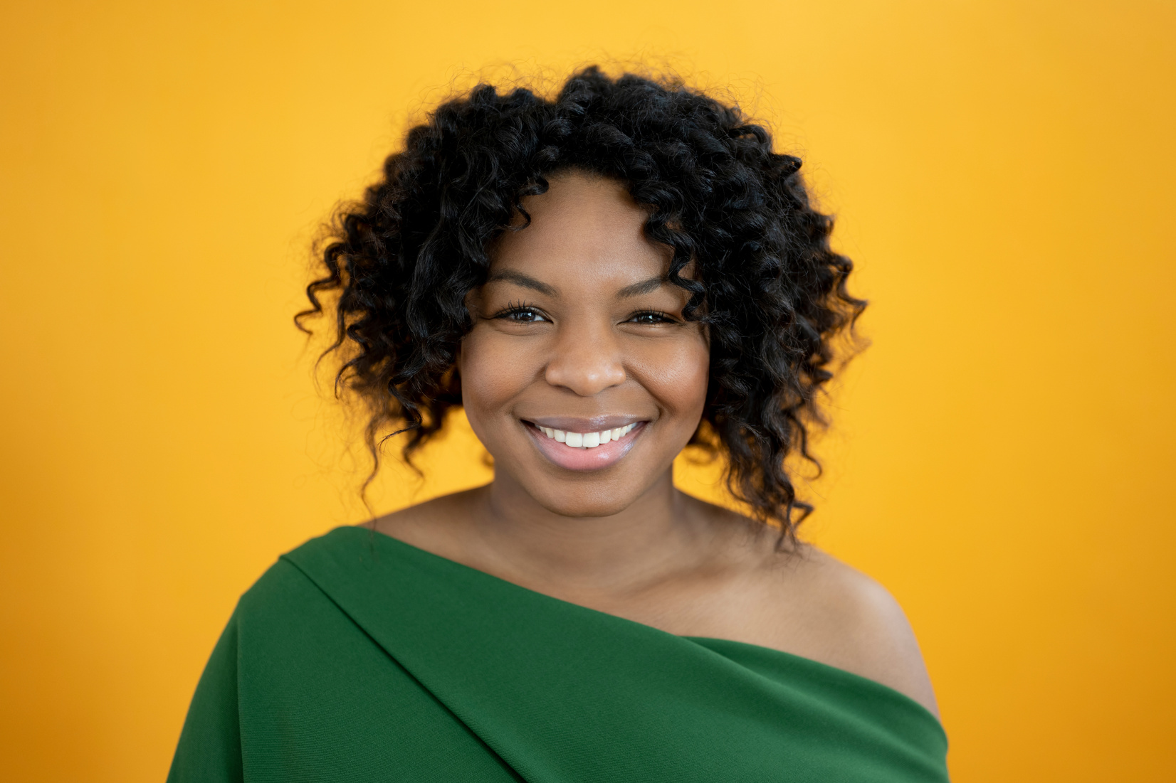 Indoor headshot portrait of cheerful 29 year old black woman